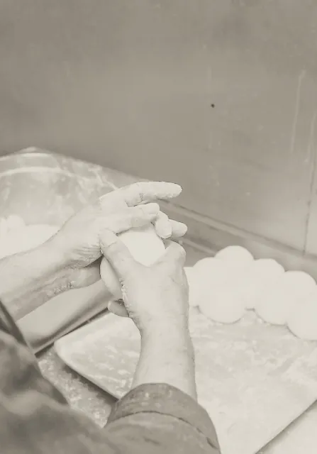 Hands dividing dough on the bench