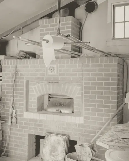 A brick oven in the corner of a bakehouse