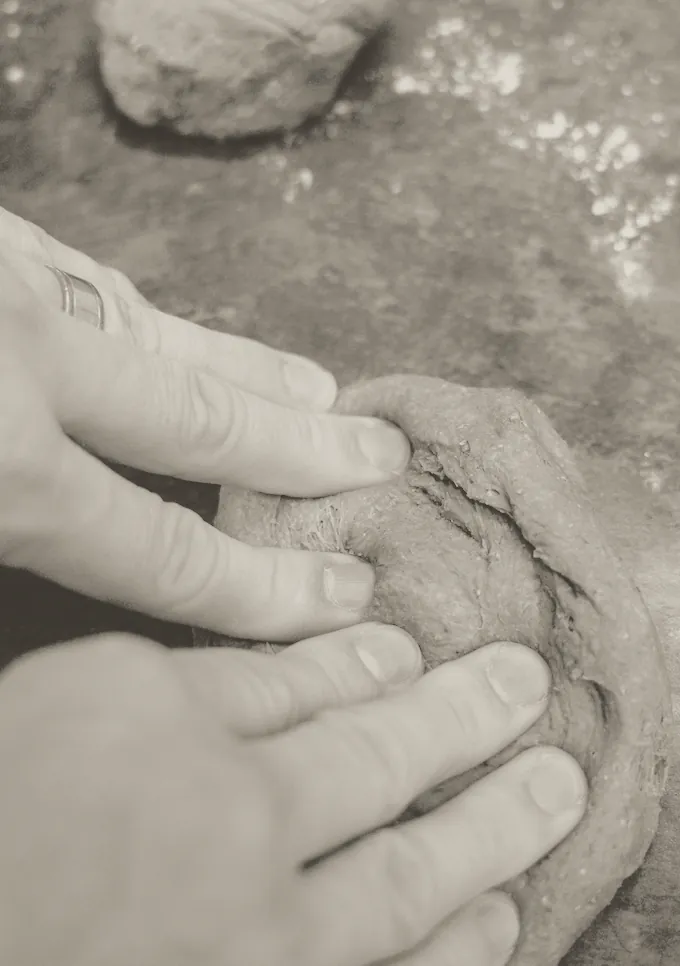 Two hands kneading a heavy rye dough